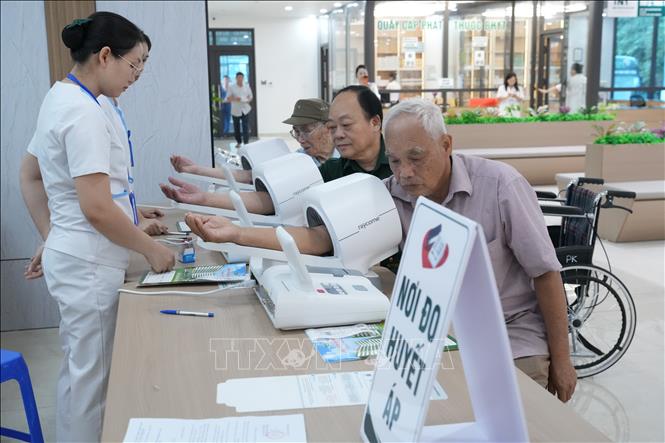 Người có công được đo huyết áp kiểm tra sức khỏe tại bệnh viện. Ảnh: Tiến Vĩnh –TTXVN 