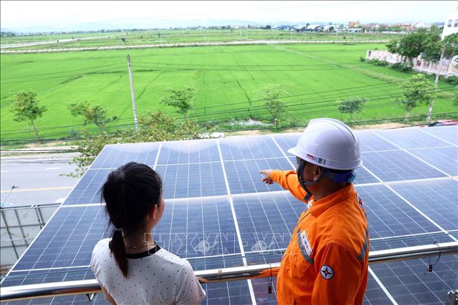 Công nhân điện lực Can Lộc (PC Hà Tĩnh) hướng dẫn người dân cách sử dụng điện mặt trời áp mái hiệu quả. Ảnh: Huy Hùng - TTXVN