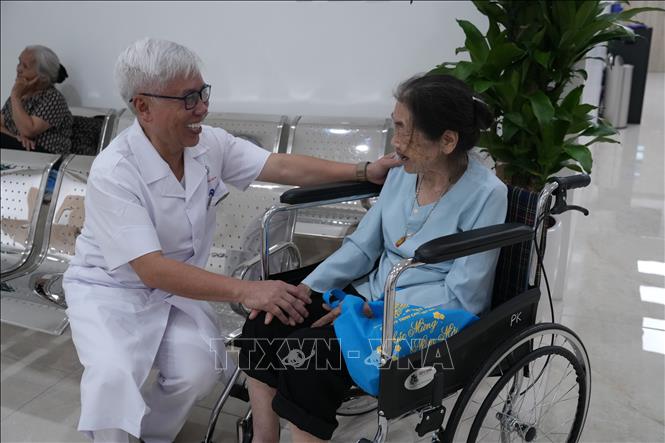 Các bác sĩ của bệnh viện thăm hỏi thân nhân gia đình liệt sĩ đến khám miễn phí. Ảnh: Tiến Vĩnh –TTXVN 
