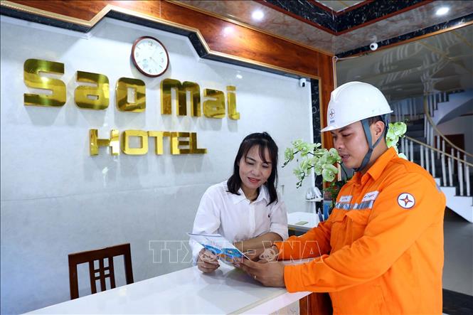Nhân viên công ty điện lực Hà Tĩnh tuyên truyền người dân thực hiện tiết kiệm điện hiệu quả. Ảnh: Huy Hùng - TTXVN