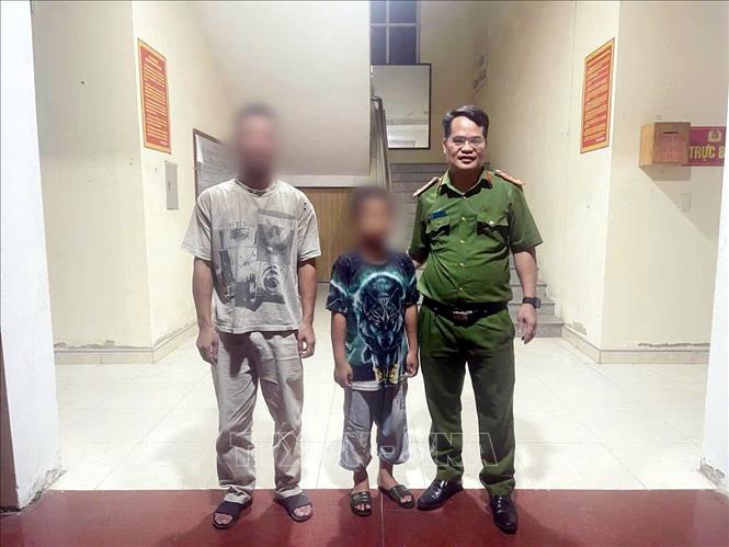 Công an xã Tân Thanh (Tuyên Quang) bàn giao cháu bé H.C.M. về nhà an toàn.. Ảnh: TTXVN phát