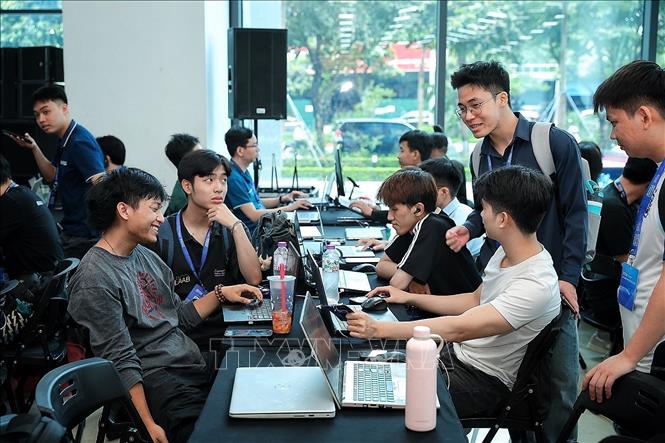 Thành viên các đội thi trao đổi trực tiếp tại khu vực làm việc, cùng rà soát ý tưởng và phân công nhiệm vụ nhằm đẩy nhanh quá trình xây dựng, thử nghiệm và tối ưu sản phẩm AI. Ảnh: Phạm Tuấn Anh - TTXVN