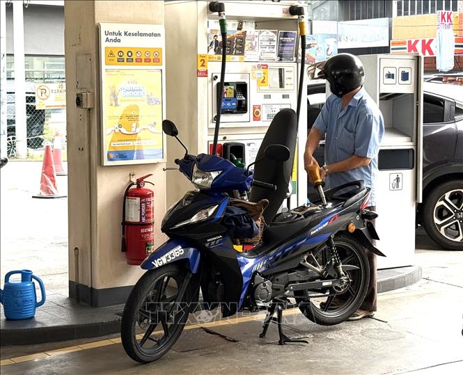 Người dân đổ xăng tại một trạm xăng ở thủ đô Kuala Lumpur. Ảnh: Thanh Bình - PV TTXVN tại Malaysia