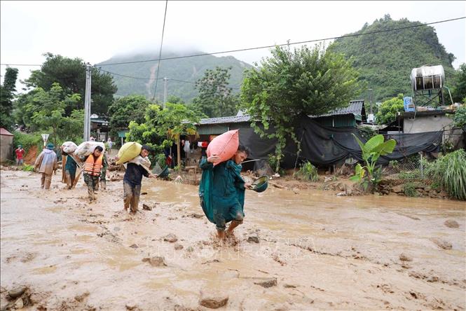 Lực lượng chức năng giúp người dân xã Mường Than di dời tài sản. Ảnh: Quý Trung - TTXVN