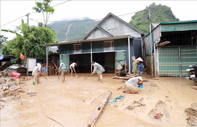 Lực lượng chức năng giúp người dân xã Mường Than khắc phục hậu quả. Ảnh: Quý Trung - TTXVN