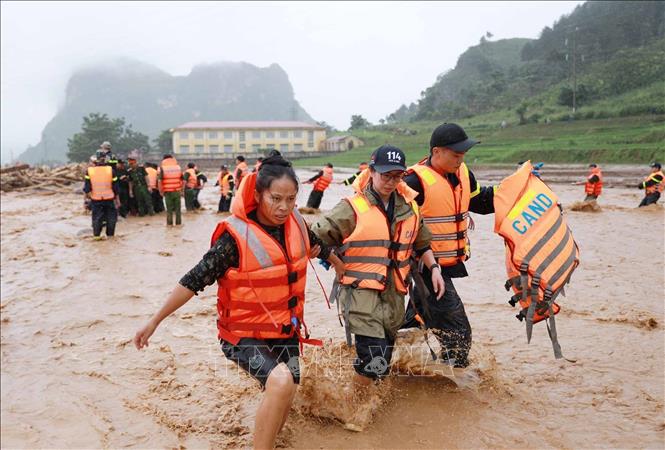 Người dân được lực lượng Công an tỉnh Lai Châu đưa từ nơi bị cô lập lên bờ. Ảnh: Quý Trung - TTXVN