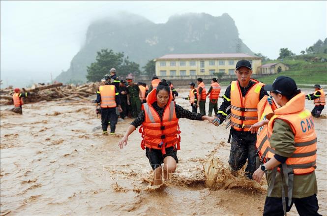 Người dân được lực lượng Công an tỉnh Lai Châu đưa từ nơi bị cô lập lên bờ. Ảnh: Quý Trung - TTXVN