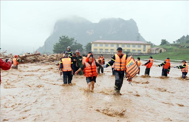 Người dân được lực lượng Công an tỉnh Lai Châu đưa từ nơi bị cô lập lên bờ. Ảnh: Quý Trung - TTXVN