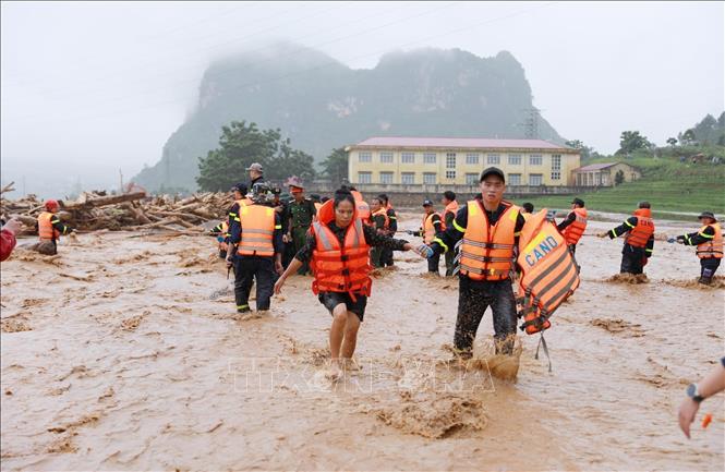 Người dân được lực lượng Công an tỉnh Lai Châu đưa từ nơi bị cô lập lên bờ. Ảnh: Quý Trung - TTXVN