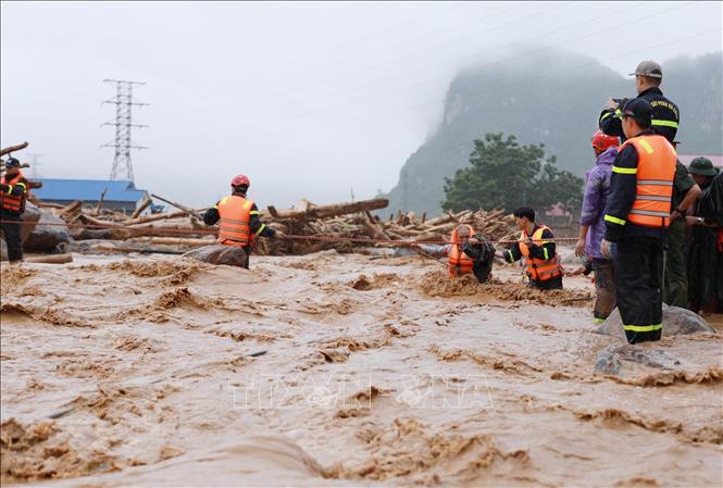 Lực lượng Công an tỉnh Lai Châu hỗ trợ cứu người bị cô lập về nơi an toàn. Ảnh: Quý Trung - TTXVN