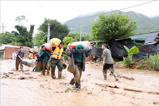 Các lực lượng chức năng hộ trợ giúp dân di chuyển tài sản đến nơi an toàn. Ảnh: Quý Trung - TTXVN
