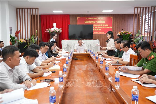 Đoàn công tác nghe UBND xã Long Điền báo cáo về tiến độ triển khai các công trình, phần việc đang thực hiện. Ảnh: Tuấn Kiệt – TTXVN