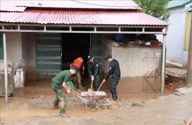 Lực lực Công an tỉnh Lai Châu hỗ trợ giúp dân khắc phục hậu quả của lũ. Ảnh: Quý Trung - TTXVN