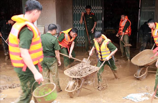 The province's police force assist local people to overcome the flash floods' aftermaths. VNA Photo: Quý Trung 
