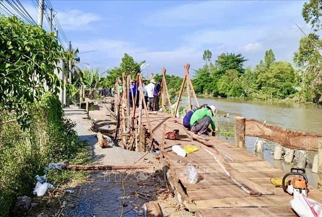 Cầu tạm được xây dựng từ nguồn xã hội hóa, góp phần bảo đảm việc đi lại, sinh hoạt và sản xuất của người dân trong thời gian chờ xử lý sạt lở. Ảnh: Thanh Sang - TTXVN
