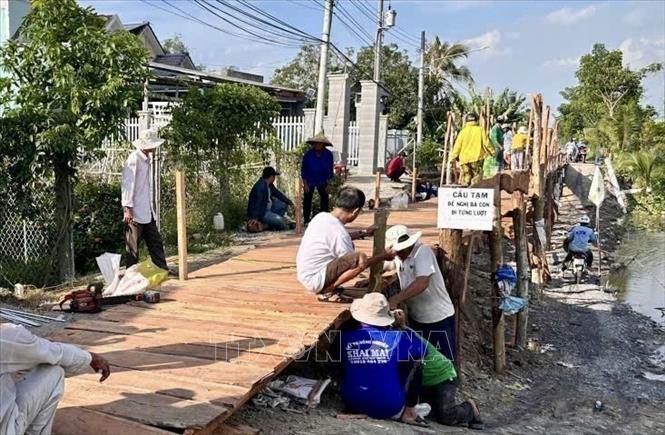 Cầu tạm được xây dựng từ nguồn xã hội hóa, góp phần bảo đảm việc đi lại, sinh hoạt và sản xuất của người dân trong thời gian chờ xử lý sạt lở. Ảnh: Thanh Sang - TTXVN
