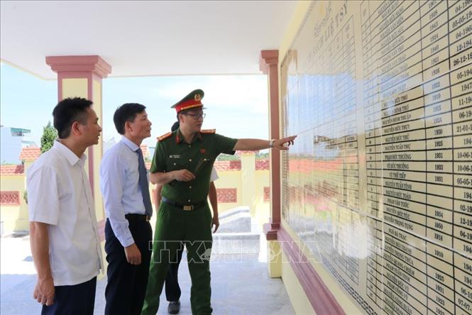 Phó Giáo sư, Tiến sĩ, Thầy thuốc ưu tú Phạm Tuấn Cảnh, Giám đốc Bệnh viện Tai Mũi Họng Trung ương (thứ 2 từ trái sang) và Bí thư Đảng ủy xã Hà Bắc Phạm Văn Hùng (ngoài cùng, bên trái) tham quan nhà bia ghi danh liệt sĩ tại Nghĩa trang liệt sĩ Tân Việt trong ngày khánh thành công trình. Ảnh: Mạnh Minh – TTXVN