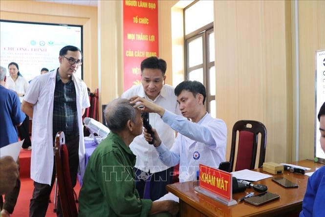 Bí thư Đảng ủy, Chủ tịch Hội đồng nhân dân xã Hà Bắc, thành phố Hải Phòng Phạm Văn Hùng (áo trắng, thứ 2 từ phải sang) thăm hỏi người có công với cách mạng tại chương trình khám bệnh. Ảnh: Mạnh Minh - TTXVN