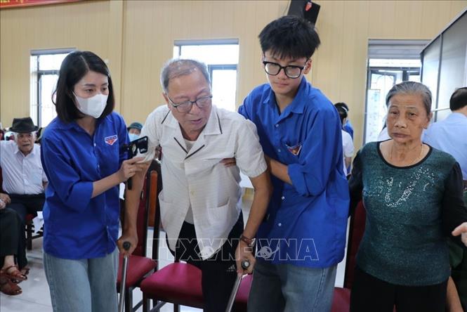 Đoàn viên thanh niên xã Hà Bắc hỗ trợ những người có công với cách mạng tại chương trình khám bệnh. Ảnh: Mạnh Minh - TTXVN