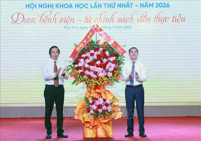 Thứ trưởng Bộ Y tế Trần Văn Thuấn tặng hoa chúc mừng hội thảo. Ảnh: Tạ Toàn - TTXVN