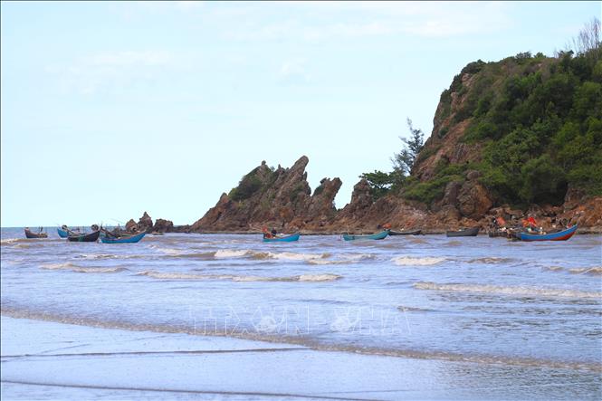 Nhiều thuyền mủng của ngư dân làng biển Quỳnh Lương (Nghệ An) neo đậu quanh núi đá ở sát bờ biển. Ảnh: Xuân Tiến - TTXVN 