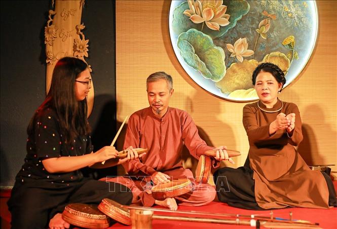 Visitors are guided in practicing the musical instruments used in the Xam singing. VNA Photo: Khánh Hoà 