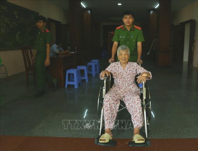 Thân nhân liệt sĩ tuổi cao sức yếu được các chiến sĩ hỗ trợ đưa đón đến điểm lấy mẫu ADN. Ảnh: Duy Khương - TTXVN