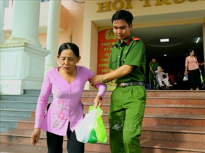 Thân nhân liệt sĩ tuổi cao sức yếu được các chiến sĩ hỗ trợ đưa đón đến điểm lấy mẫu ADN. Ảnh: Duy Khương - TTXVN