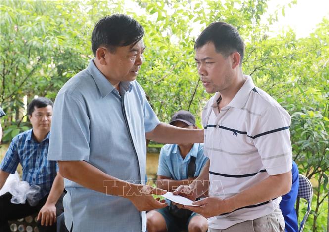 Thứ trưởng Nguyễn Hoàng Hiệp thăm hỏi, tặng quà cho người dân có vợ bị lũ cuốn trôi và mất hết tài sản cùng nhà cửa tại xã Mường Than, tỉnh Lai Châu. Ảnh: Quý Trung – TTXVN