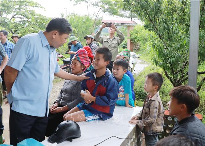 Thứ trưởng Nguyễn Hoàng Hiệp thăm hỏi trẻ em, học sinh là con của các hộ gia đình bị lũ ống, lũ quét gây ra mất hết tài sản cùng nhà cửa tại xã Mường Than, tỉnh Lai Châu. Ảnh: Quý Trung – TTXVN
