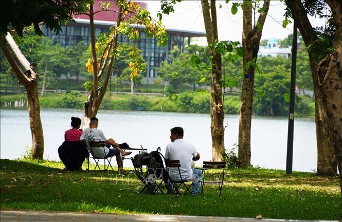 Người dân đến công viên bờ Bắc sông Hương, thành phố Huế để hóng mát, tránh nắng nóng gay gắt. Ảnh: Nguyên Lý - TTXVN