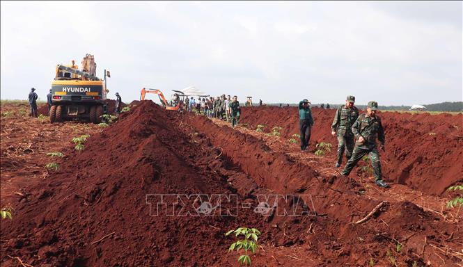 Tại hiện trường, các cán bộ, chiến sĩ làm việc liên tục trong điều kiện thời tiết nắng nóng. Ảnh: Đậu Tất Thành - TTXVN.