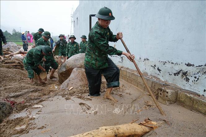 Các cán bộ, chiến sĩ tìm kiếm người mất tích trong lũ. Ảnh: Nguyễn Oanh-TTXVN