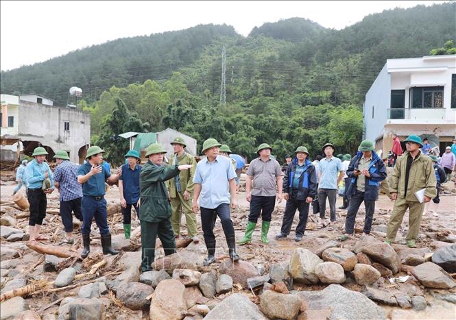 Chủ tịch UBND tỉnh Lai Châu trao đổi với Thứ trưởng Nguyễn Hoàng Hiệp về sự việc lũ ống, lũ quét gây ra tại xã Mường Than, tỉnh Lai Châu. Ảnh: Quý Trung - TTXVN