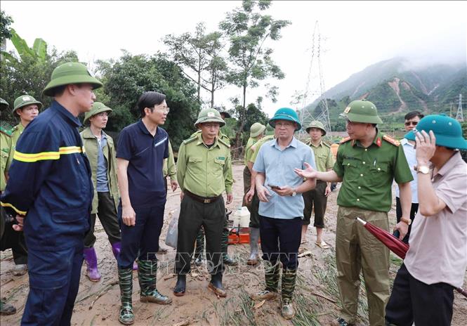 Các lực lựng phối hợp khơi dòng nước để di dời người dân cũng như tài sản ra khỏi nới nguy hiểm tại Bản Chít. Ảnh: Quý Trung - TTXVN
