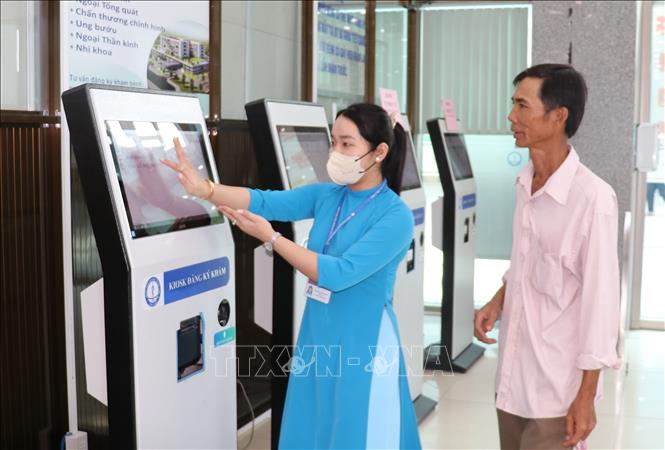 Bệnh nhân được hướng dẫn làm thủ tục đăng ký khám bệnh trực tuyến. Ảnh: Hữu Chí - TTXVN