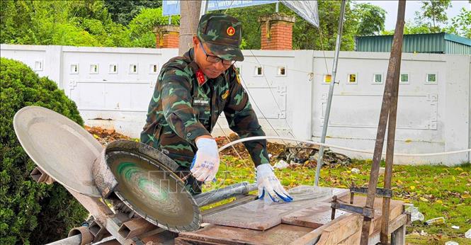 Trung tá Nguyễn Văn Ngọc với chiếc máy mòi đá. Ảnh: TTXVN phát