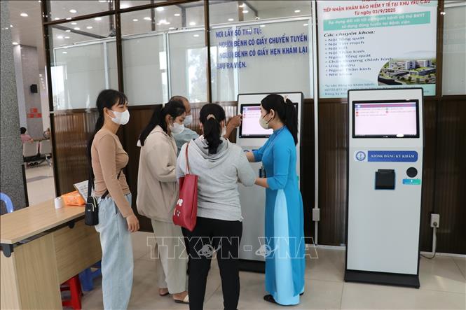 Nhân viên Bệnh viện Đa khoa Tiền Giang, tỉnh Đồng Tháp hướng dẫn người bệnh làm thủ tục đăng ký khám bệnh trực tuyến. Ảnh: Hữu Chí - TTXVN