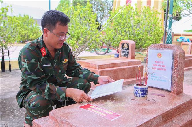 Lực lượng chức năng kiểm tra thông tin về phần mộ liệt sĩ. Ảnh: Công Luật - TTXVN