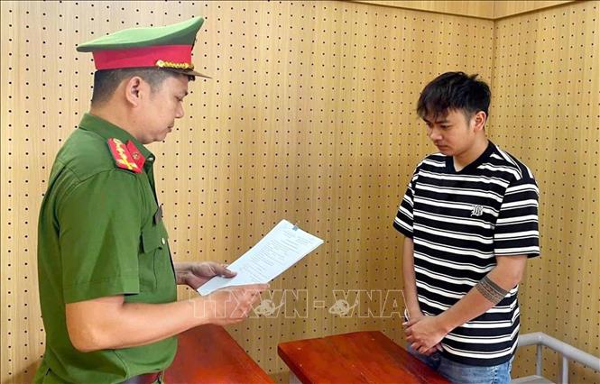 Công an đọc quyết định khởi tố Trần Đình Hoàng. Ảnh: TTXVN phát