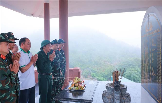 Các thành viên đoàn thắp hương tri ân các liệt sĩ tại tưởng niệm liệt sĩ tại xã Bạch Đích. Ảnh: Hoàng Hiếu - TTXVN