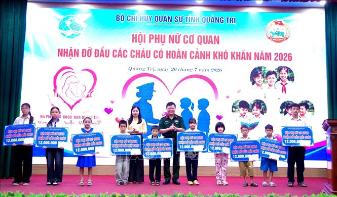 Thủ trưởng Bộ Chỉ huy Quân sự tỉnh Quảng Trị và đại diện Hội Liên hiệp Phụ nữ tỉnh trao biển tượng trưng hỗ trợ các em trong chương trình. Ảnh: Võ Dung - TTXVN