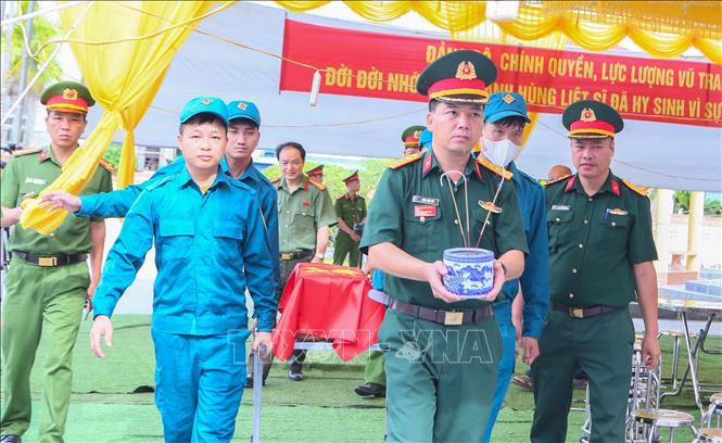 Lực lượng chức năng làm lễ đưa hài cốt liệt sĩ về khu vực lấy mẫu sinh phẩm. Ảnh: Công Luật - TTXVN