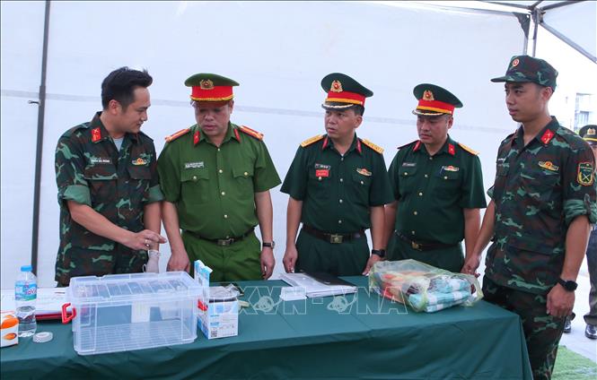 Tổ công tác tìm kiếm, quy tập và xác định danh tính hài cốt liệt sĩ tại khu vực nghĩa trang liệt sĩ phường Nam Định trao đổi các quy trình lấy mẫu sinh phẩm ADN tại các phần mộ liệt sĩ chưa xác định. Ảnh: Công Luật - TTXVN
