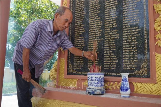 Ông Dương Văn Xướng thắp hương tri ân trước bia tưởng niệm. Ảnh: Mai Trang- TTXVN 