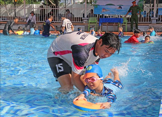 Các chiến sĩ trong Đội chữa cháy và cứu nạn cứu hộ khu vực Mỹ Thới tận tình hướng dẫn học sinh kỹ năng giữ thăng bằng và nổi trên mặt nước khi bơi. Ảnh: Công Mạo - TTXVN
