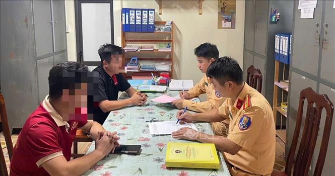 Hai tài xế xe khách làm việc với cảnh sát giao thông (Công an tỉnh Tuyên Quang). Ảnh: TTXVN phát