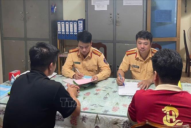 Hai tài xế xe khách làm việc với cảnh sát giao thông (Công an tỉnh Tuyên Quang). Ảnh: TTXVN phát