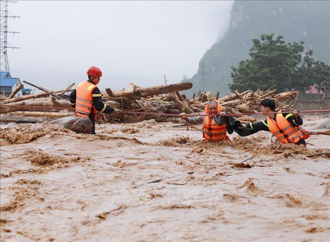 Lực lượng Công an Lai Châu hỗ trợ cứu người bị cô lập về nơi an toàn. Ảnh: Quý Trung - TTXVN