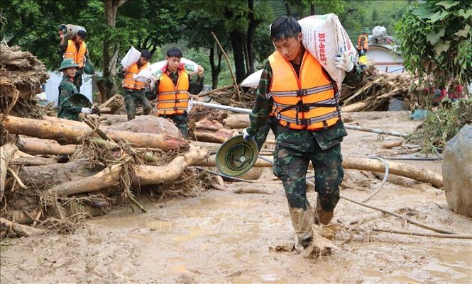 Lực lượng quân đội giúp người dân di dời tài sản đến nơi an toàn. Ảnh: Nguyễn Oanh - TTXVN